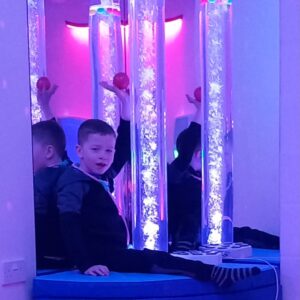 Child engaging with sensory bubble tubes in a calming sensory room