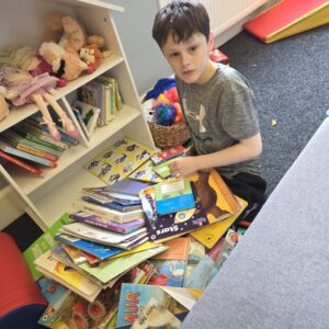 Young person exploring books and literacy activities during a support session