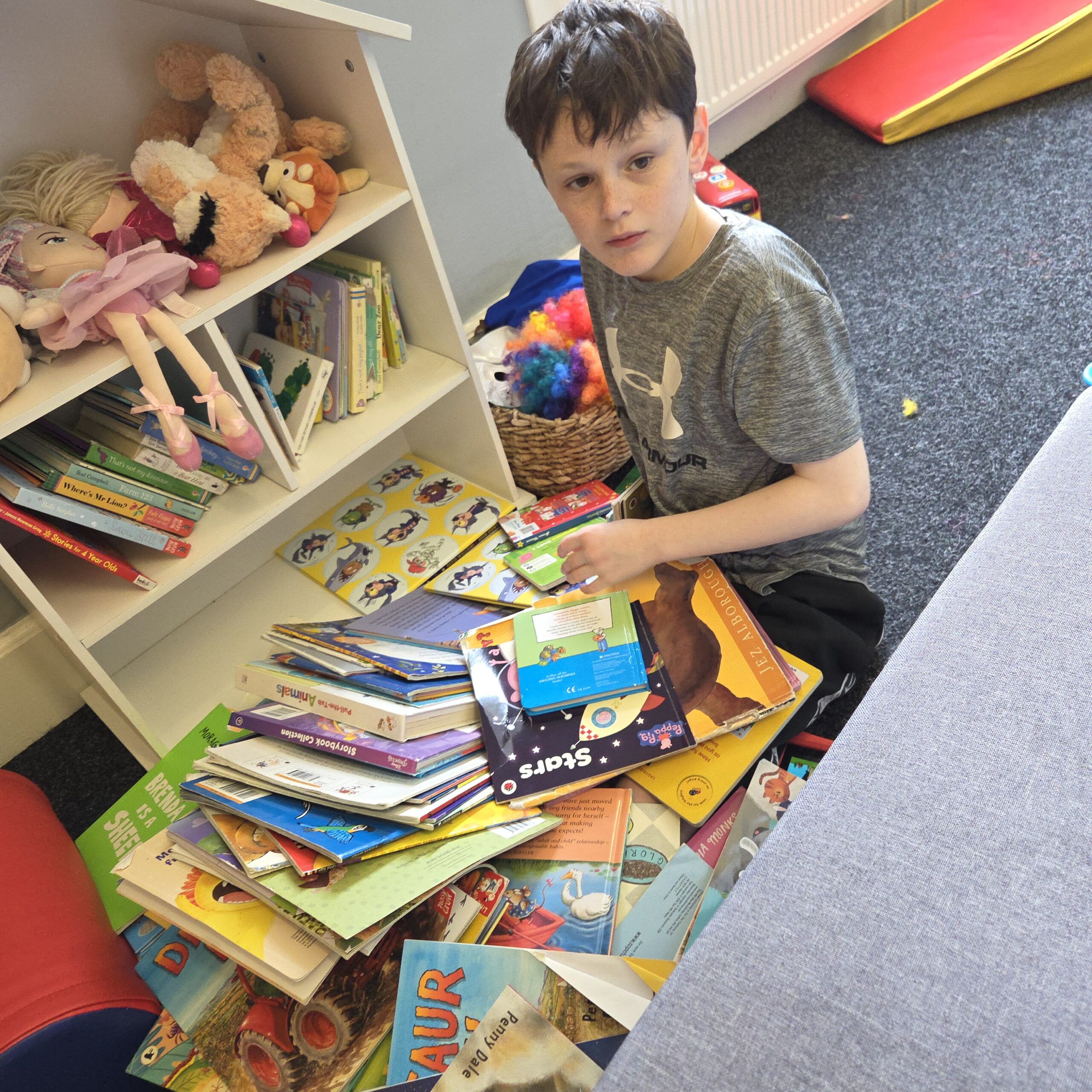 Young person exploring books and literacy activities during a support session