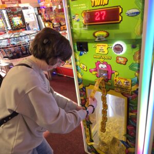 Young person enjoying an arcade activity during a community outing