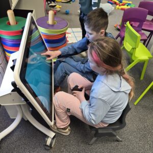 Children using an interactive sensory touchscreen during a group session