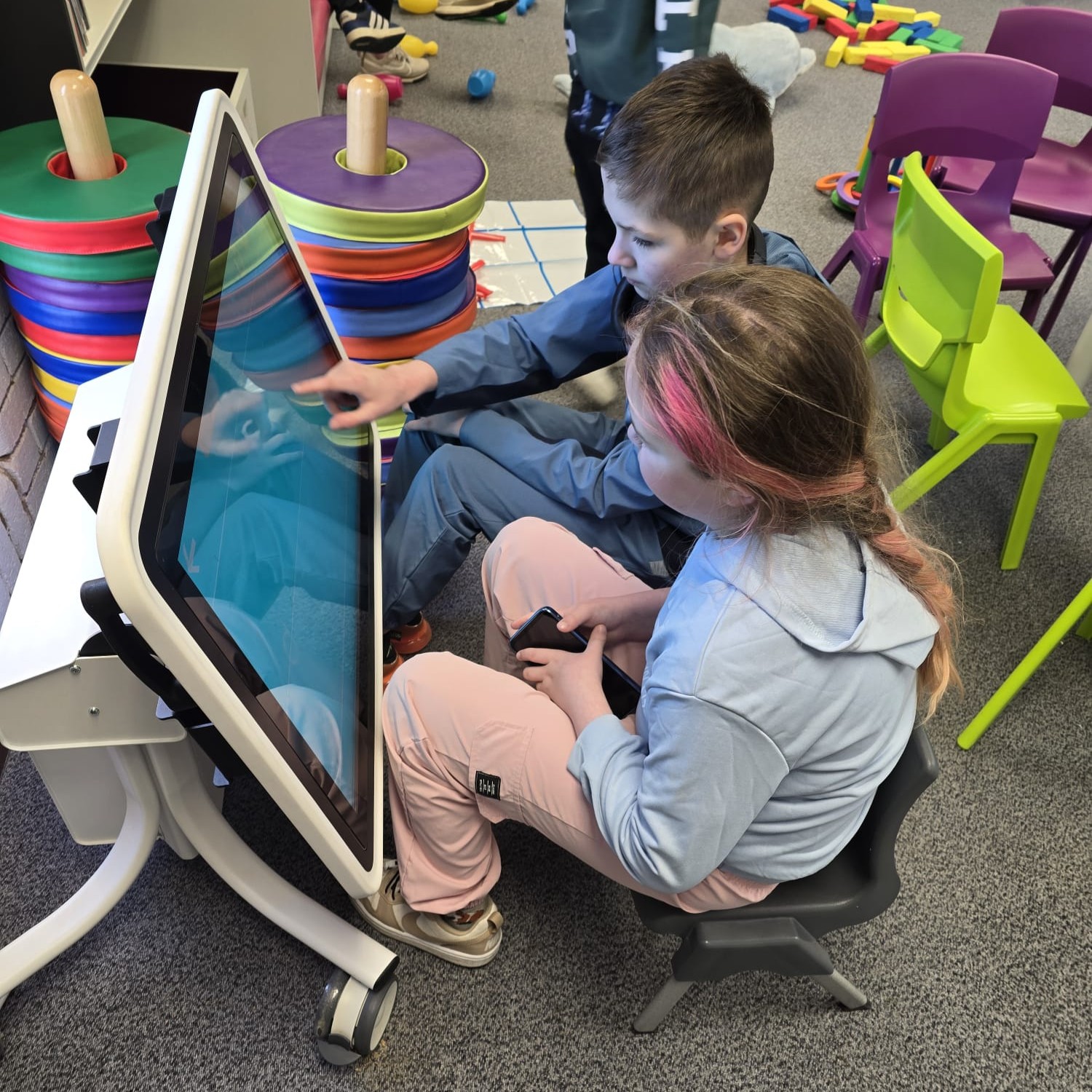 Children using an interactive sensory touchscreen during a group session