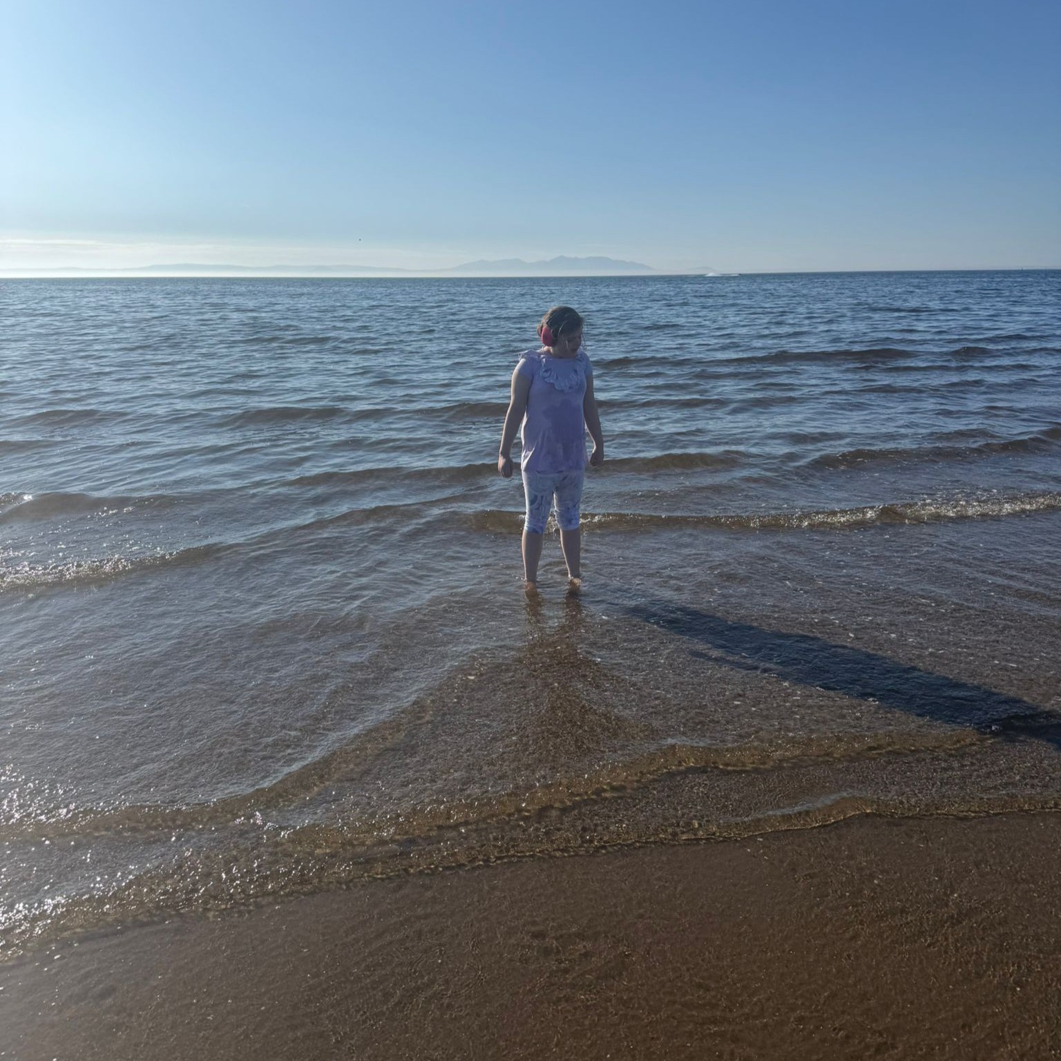 Young person enjoying a calm outdoor wellbeing activity at the beach
